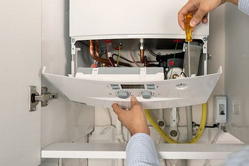 Heating technician repairing a residential boiler in El Dorado Hills