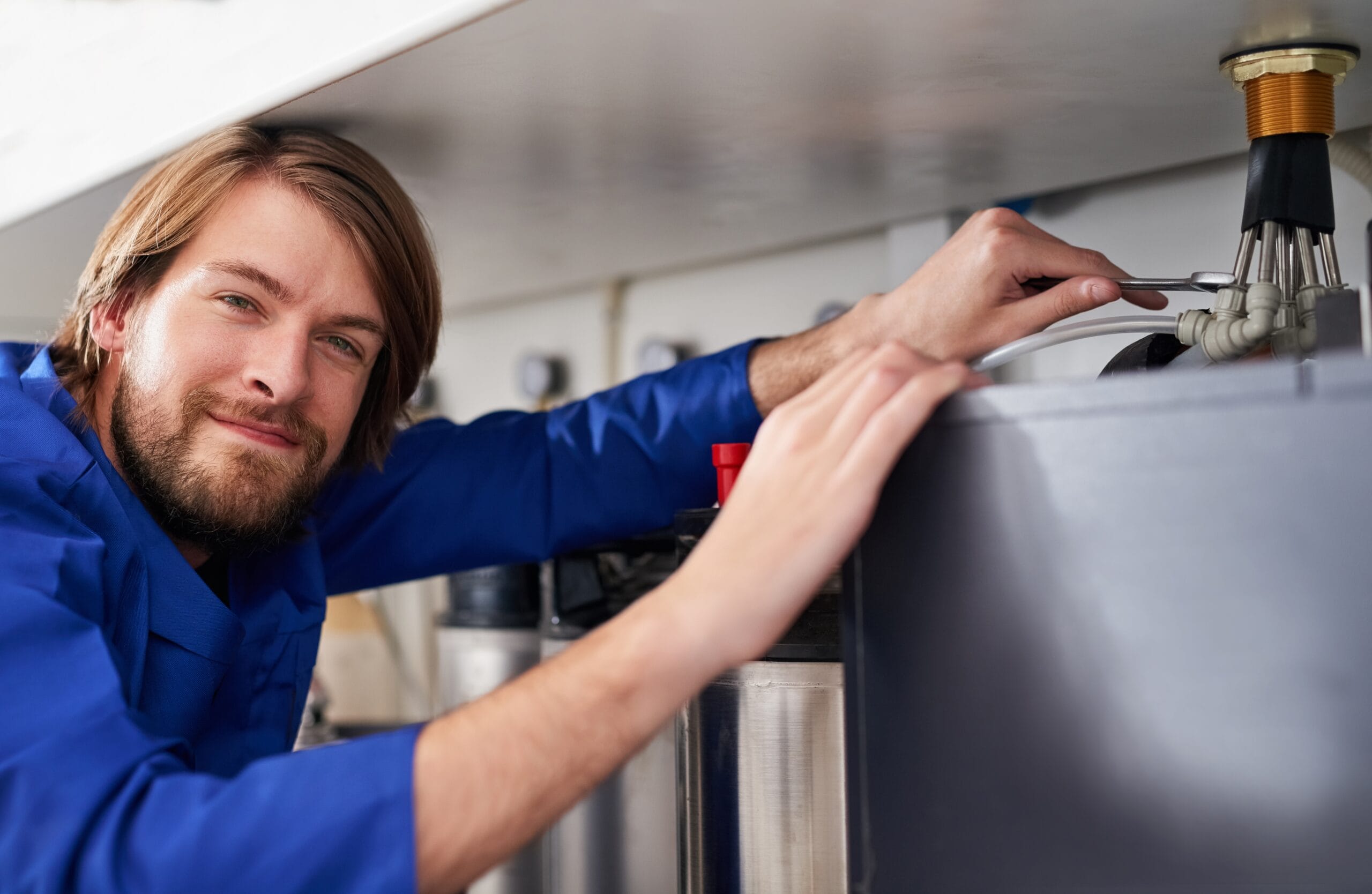 Technician servicing a residential water heater tank in El Dorado Hills